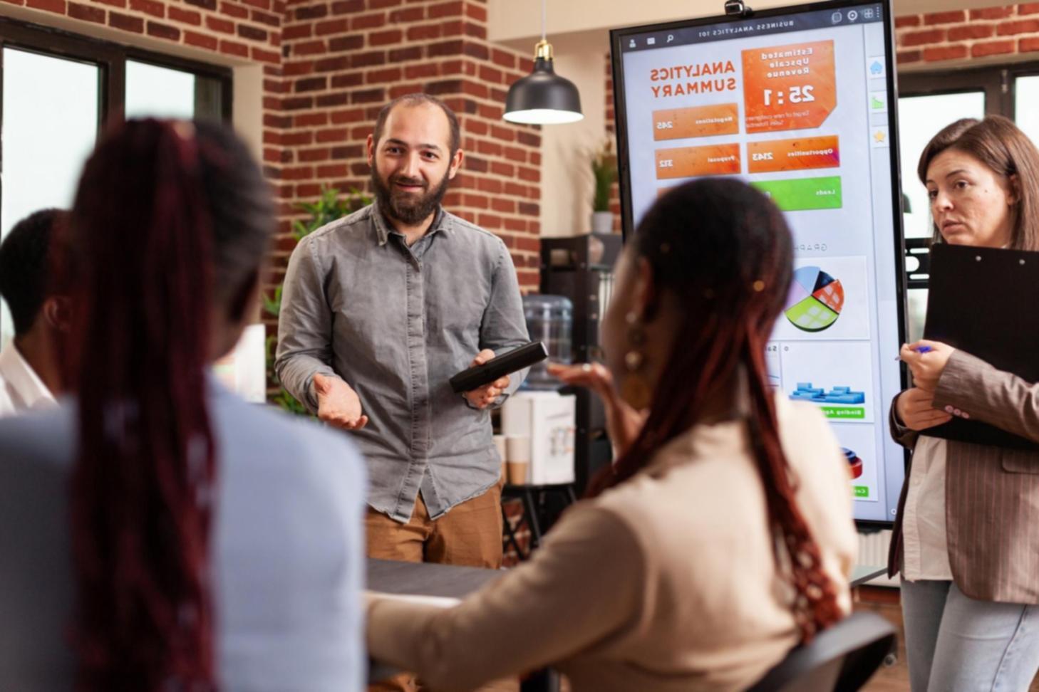 Gruppo di professionisti discute modelli previsionali durante sessione formativa